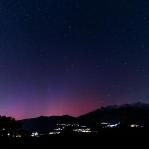 Fins rayons roses de l’aurore au-dessus d’une ligne de crêtes enneigées, sous un ciel bleu nuit étoilé