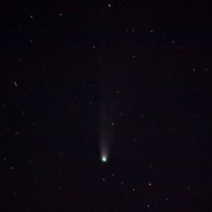 Comète à la chevelure verte et à la longue queue pâle, au milieu d’un ciel noir parsemé d’étoiles